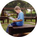 Enfant lisant un livre en plein air